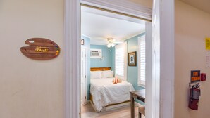 Un dormitorio con cama, ventilador de techo y extintor.