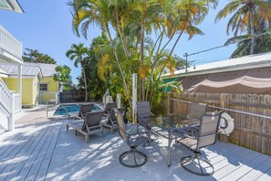 A deck with outdoor furniture and a pool. - Leo's Lodge | Newly Updated! (Key West)