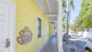 A yellow building with a porch, a sign reading "The Gallery," and the number 1016. - Leo's Lodge | Newly Updated! (Key West)