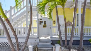 A white wooden staircase leading to a yellow building with a sign reading "1016 Galleria." - Leo's Lodge | Newly Updated! (Key West)