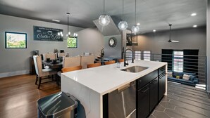 Et moderne køkken med en stor ø, spiseplads og skilt med skrift 'kaffebar'.