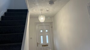Eine Treppe mit strukturierter Decke und einem Chandelier.