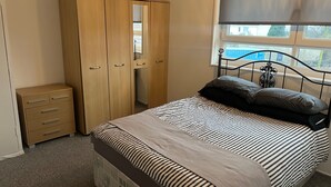 Ein Schlafzimmer mit Bett, Kleiderschrank und Fenster.