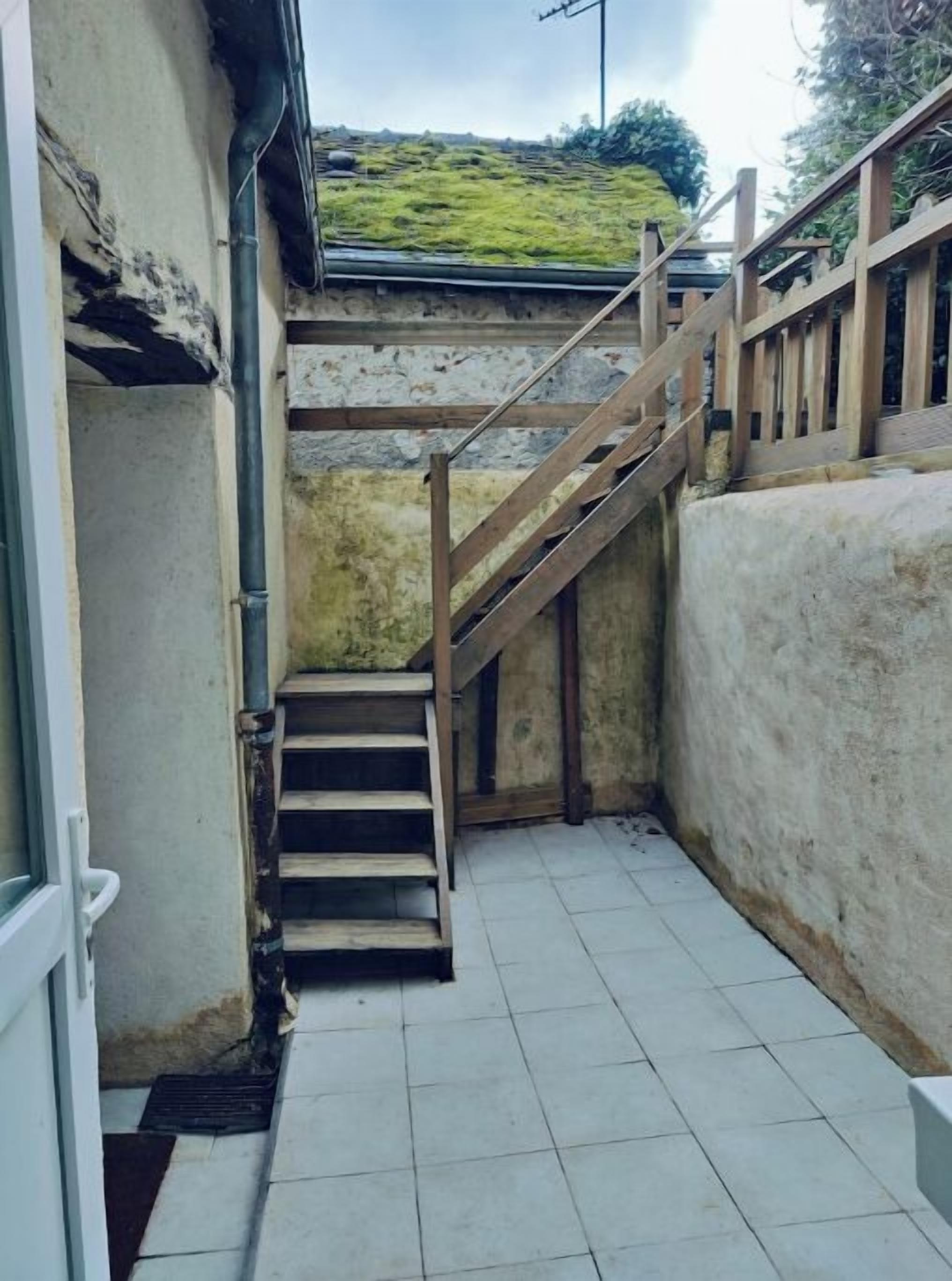 A narrow stairway with wooden railings leading to a higher level.
