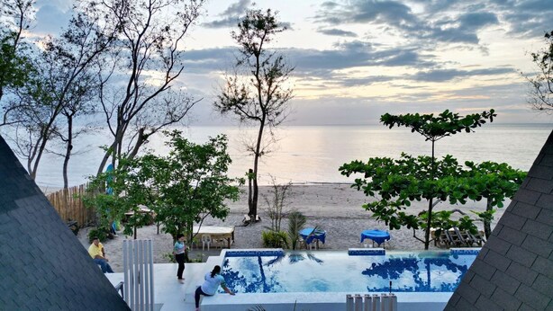A swimming pool with a view of the beach and the sea. - Suite Room 1 (Sipalay City)