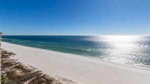 A beach with a clear sky, a sandy shore, and a staircase leading down to the beach. - Bluewater 1501 | Beach Front (Orange Beach)