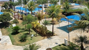 Un hôtel à plusieurs étages, doté d’un espace piscine avec des toits bleus et de palmiers.