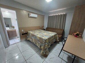 Cozy retreat with a single bed, kitchenette, and a window with a view.