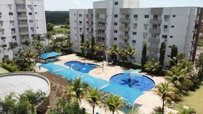Relax by the pool surrounded by lush greenery and palm trees.