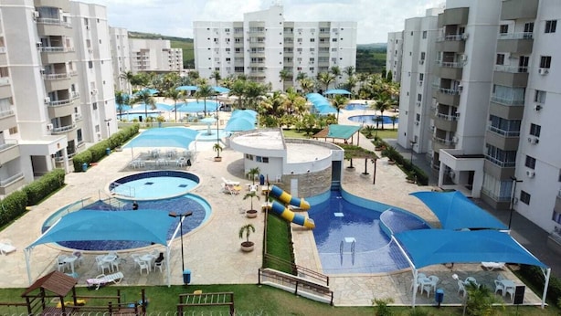 Un complexe hôtelier doté de plusieurs piscines, de chaises longues et de parasols.