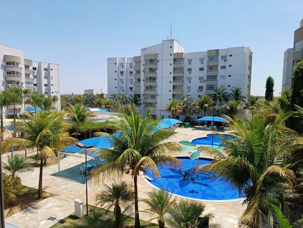 Relax by the resort's multiple pools surrounded by palm trees and shaded by umbrellas.