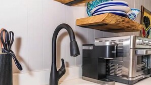 A kitchen with a stainless steel sink, a black faucet, a coffee maker, and a toaster. - CARACUL, a cozy stay for four in the lodge of Karoo at Smith Mountain Lake  (Wirtz)
