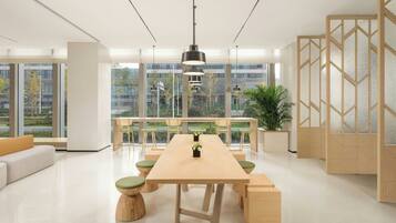 Una sala de reuniones moderna y bien iluminada, con una mesa larga, asientos cómodos y ventanas amplias que ofrecen vistas al exterior.