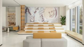 Un interior moderno con una zona de estar, una escalera y una pared con arte abstracto.