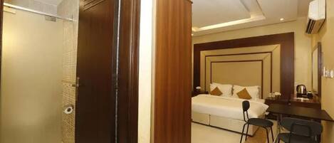 A hotel room with a bed, a desk, and a chair.