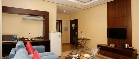 Una sala de estar moderna con un sofá, una mesa de centro, televisor y un comedor.