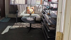 A cozy room with a sofa, a small table, and a shelving unit.