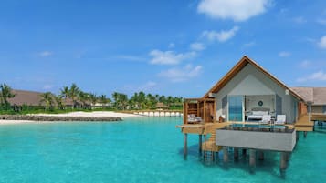 An overwater bungalow with a private pool, wooden deck, and lounge chairs.