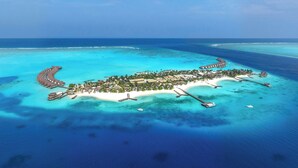 An aerial view of a tropical island resort with overwater bungalows, a sandy beach, and clear turquoise waters. - JW Marriott Maldives Kaafu Atoll Island Resort (Hathaa Finolhu)