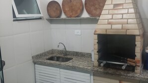 Eine Küche mit Backofen, Spüle und drei hängenden Holznäpfen.