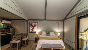 Une chambre à coucher de taille réduite, comprenant un lit, des tables de chevet, un petit bureau et une chaise.