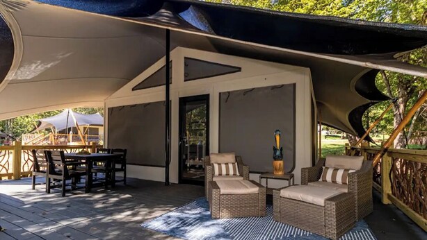 Une terrasse extérieure avec des meubles en osier, une table et une chaise.