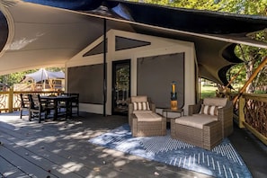 An outdoor deck with wicker furniture, a table, and a chair. - STELLENBOSCH, a Unique Luxury Cabin Experience, at Karoo Smith Mountain Lake (Wirtz)