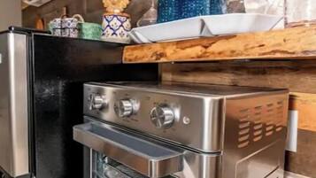 Horno, cafetera y tetera, utensilios de cocina y comedor