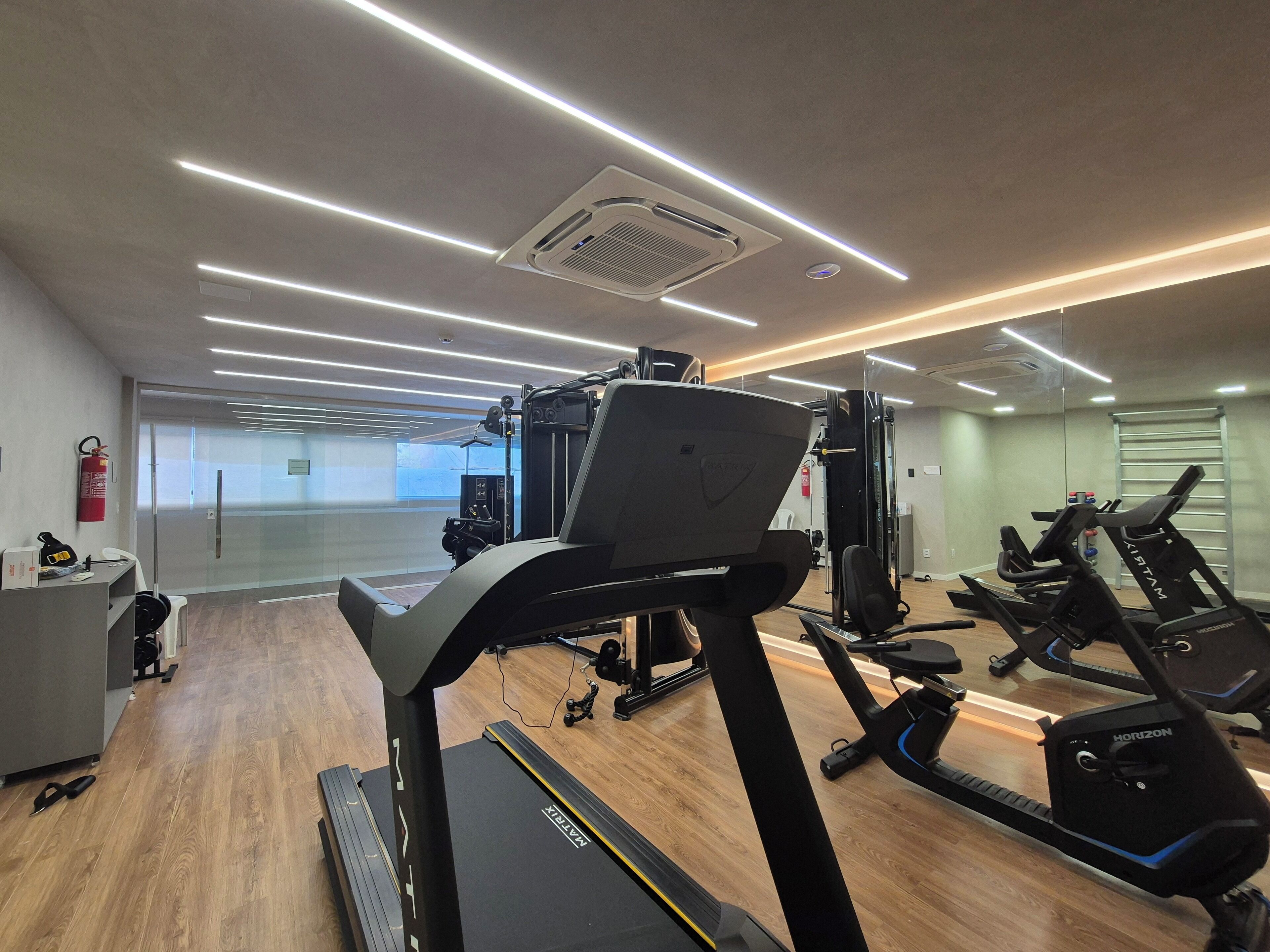 A gym with treadmills, elliptical machines, and weightlifting equipment.