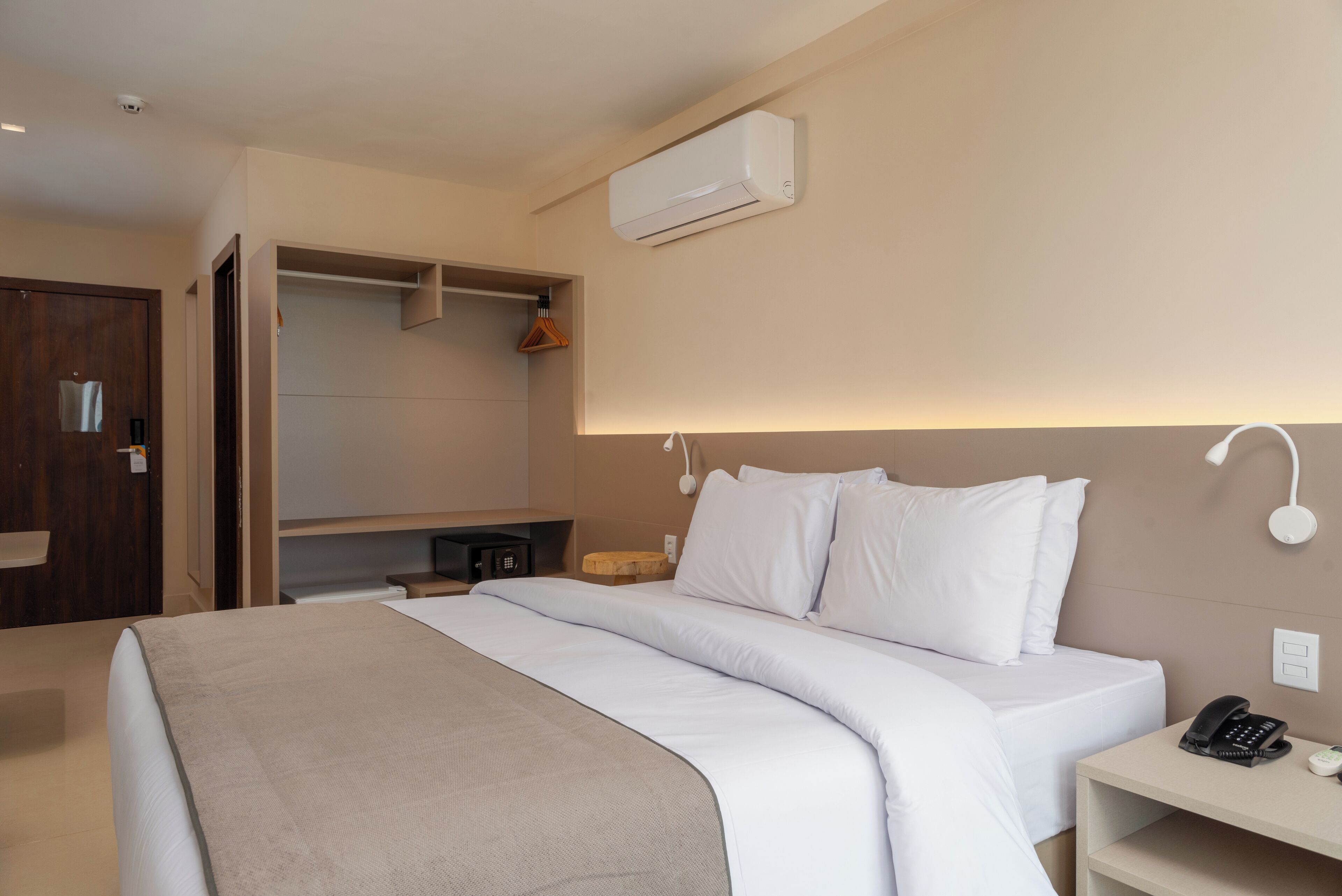 Una camera d'albergo con un letto, un comodino e un armadio.