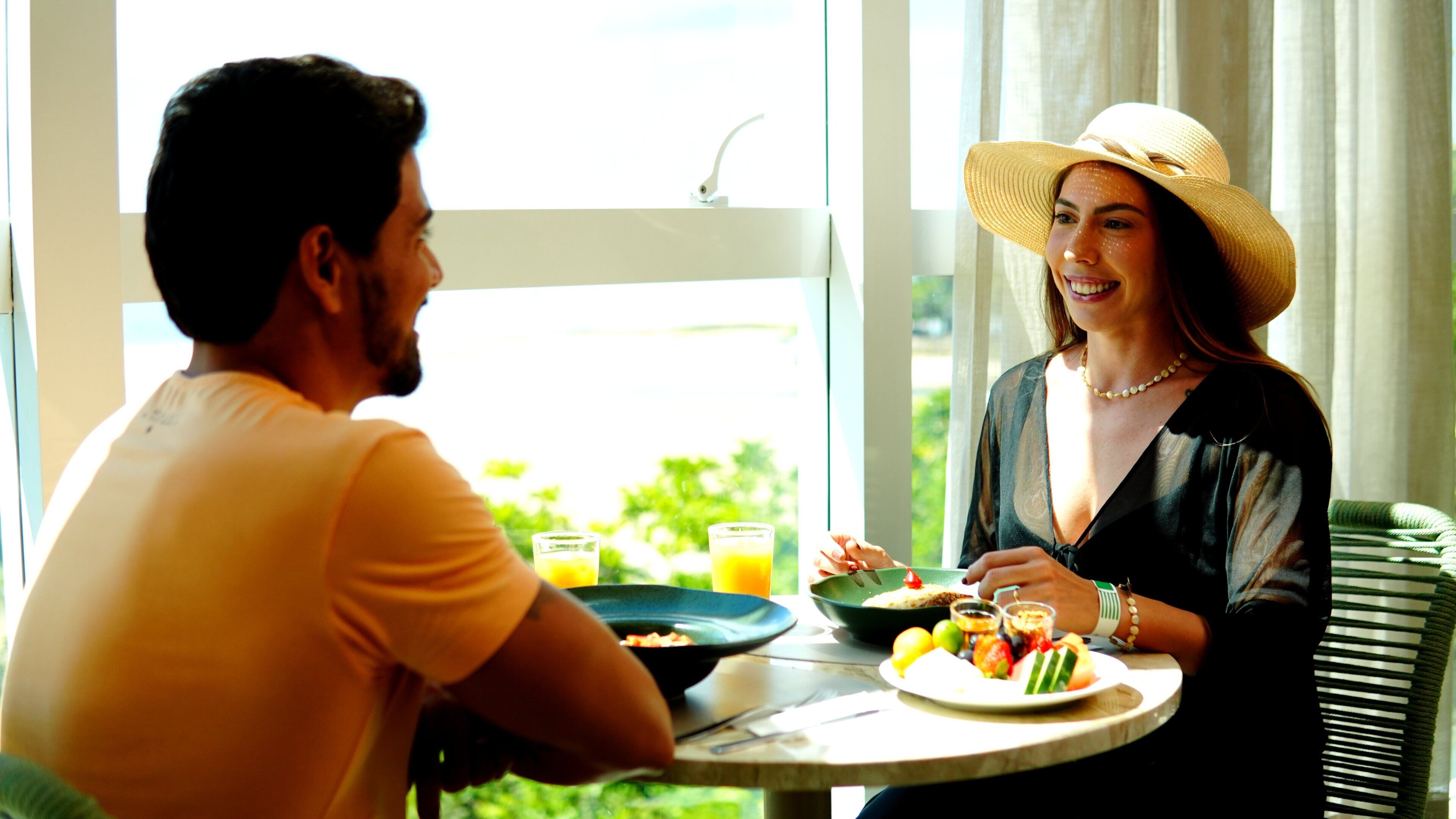 Ein Esstisch mit Mahlzeit, Fenster und Blick ins Grüne.
