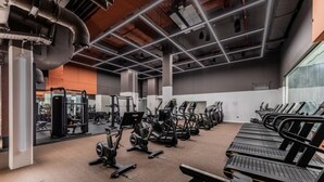 A gym with various exercise equipment, including treadmills and weight machines. - London East Village Apartment With City Views (London)