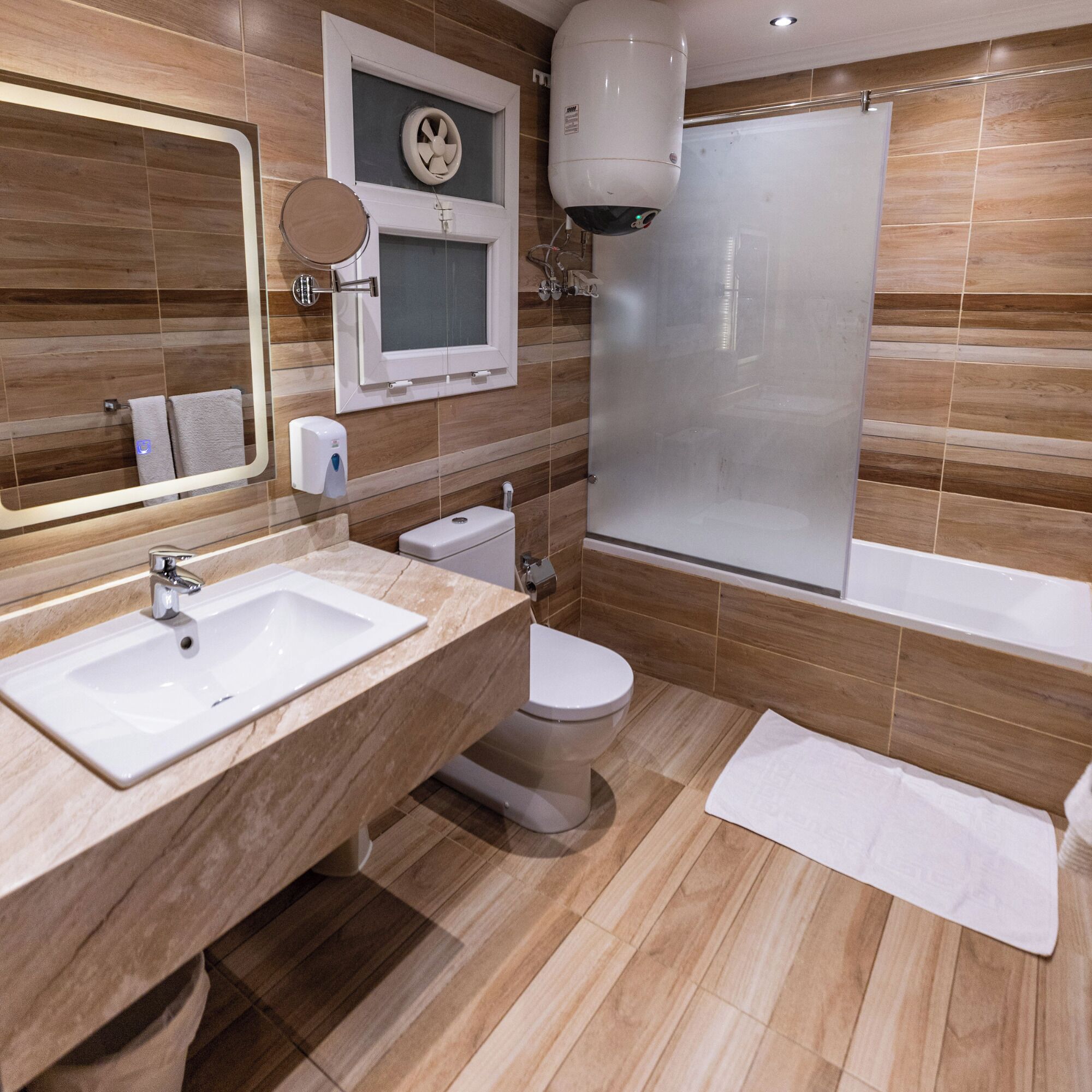 Un baño moderno con un lavamanos grande, inodoro y bañera.