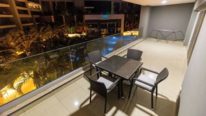 A balcony with a pool, chairs, and a table. - Ocean Apartments (Cairo)