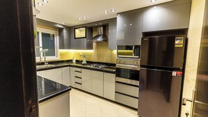 A modern kitchen with stainless steel appliances, a window above the sink, and a tiled backsplash. - Ocean Apartments (Cairo)