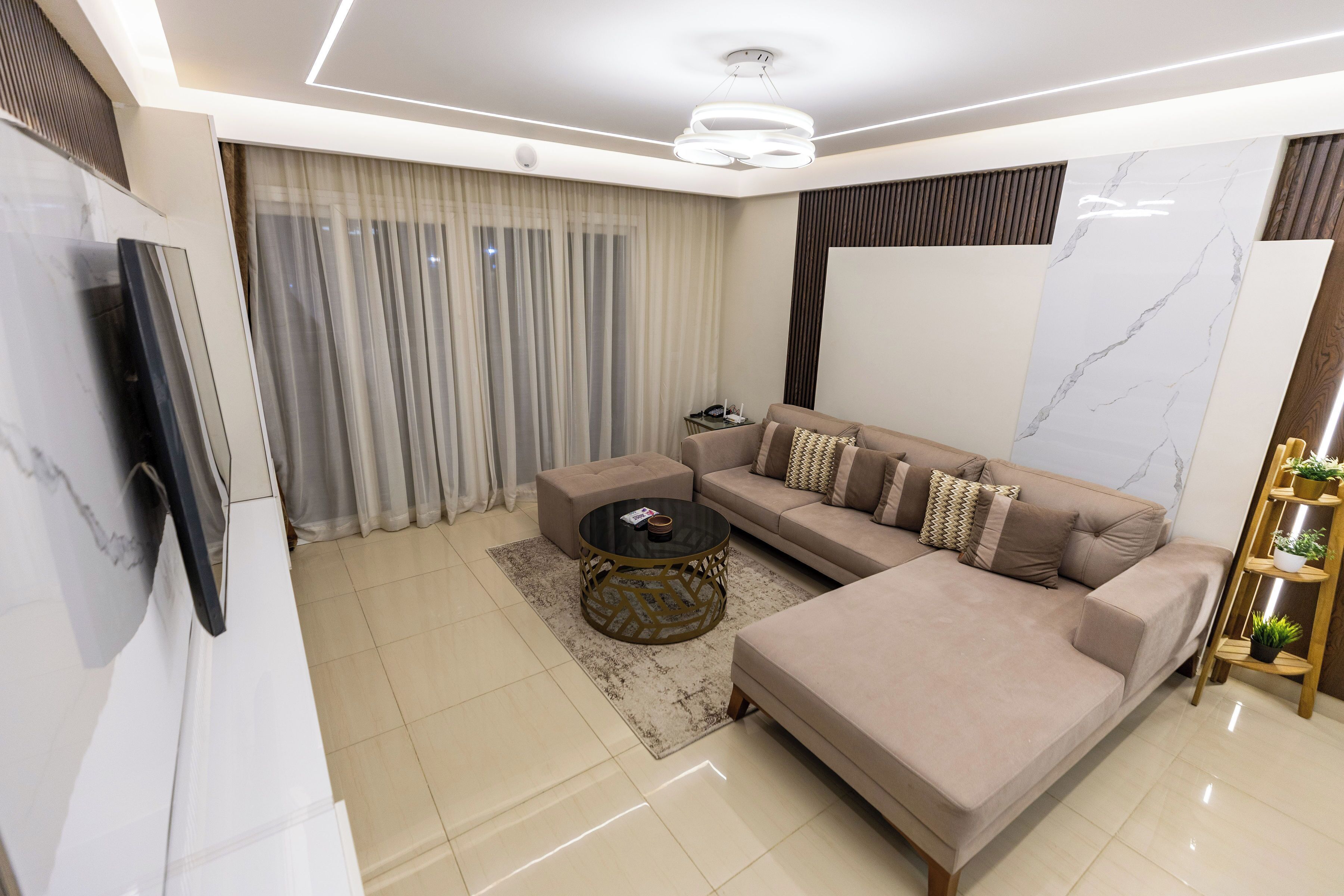 A modern living room with a sofa, coffee table, and TV.