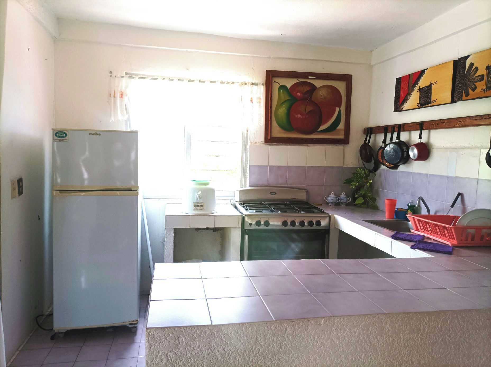 A kitchen with a refrigerator, stove, and tiled backsplash.