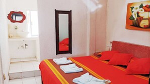 Une chambre d’hôtel avec un lit, une salle de bain et un tableau au mur.