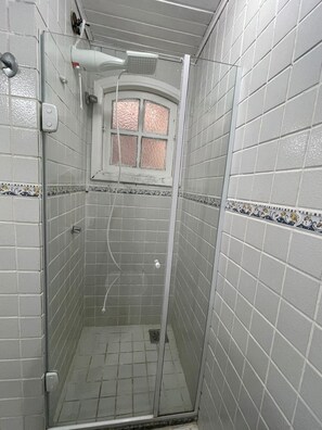 Een douche, handdoeken, zeep, toiletpapier