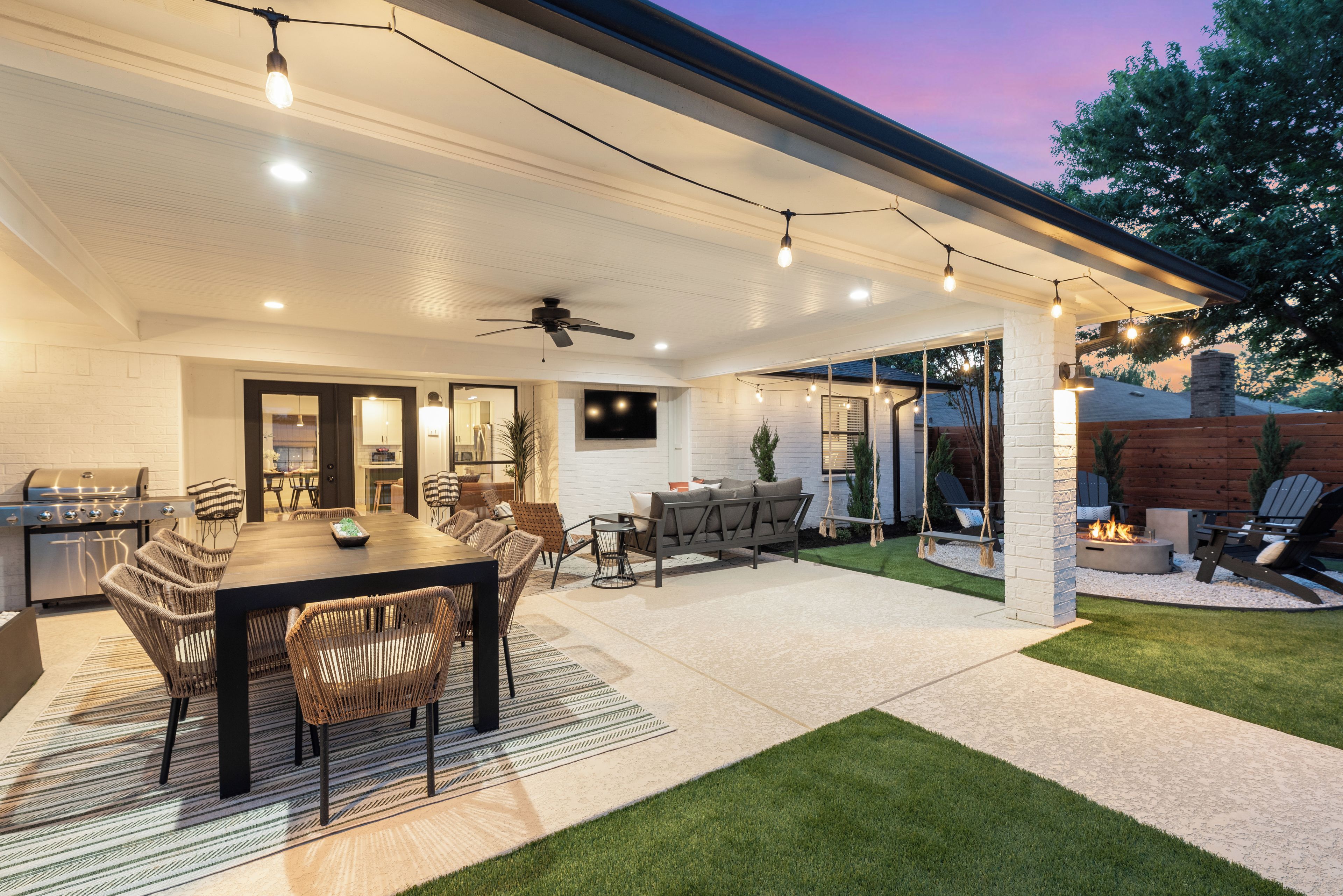 Une terrasse extérieure avec une table à manger, des chaises et un espace barbecue.