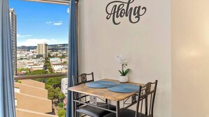A dining area with a table, chairs, and a view of the city through a large window.