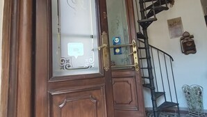 Una puerta de madera con un panel de vidrio, una escalera en espiral y un suelo con diseño.