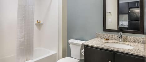 A modern bathroom with a bathtub, toilet, and sink.