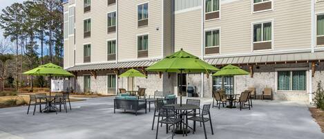 Eine Hotelterrasse mit Sitzgelegenheiten und Sonnenschirmen.