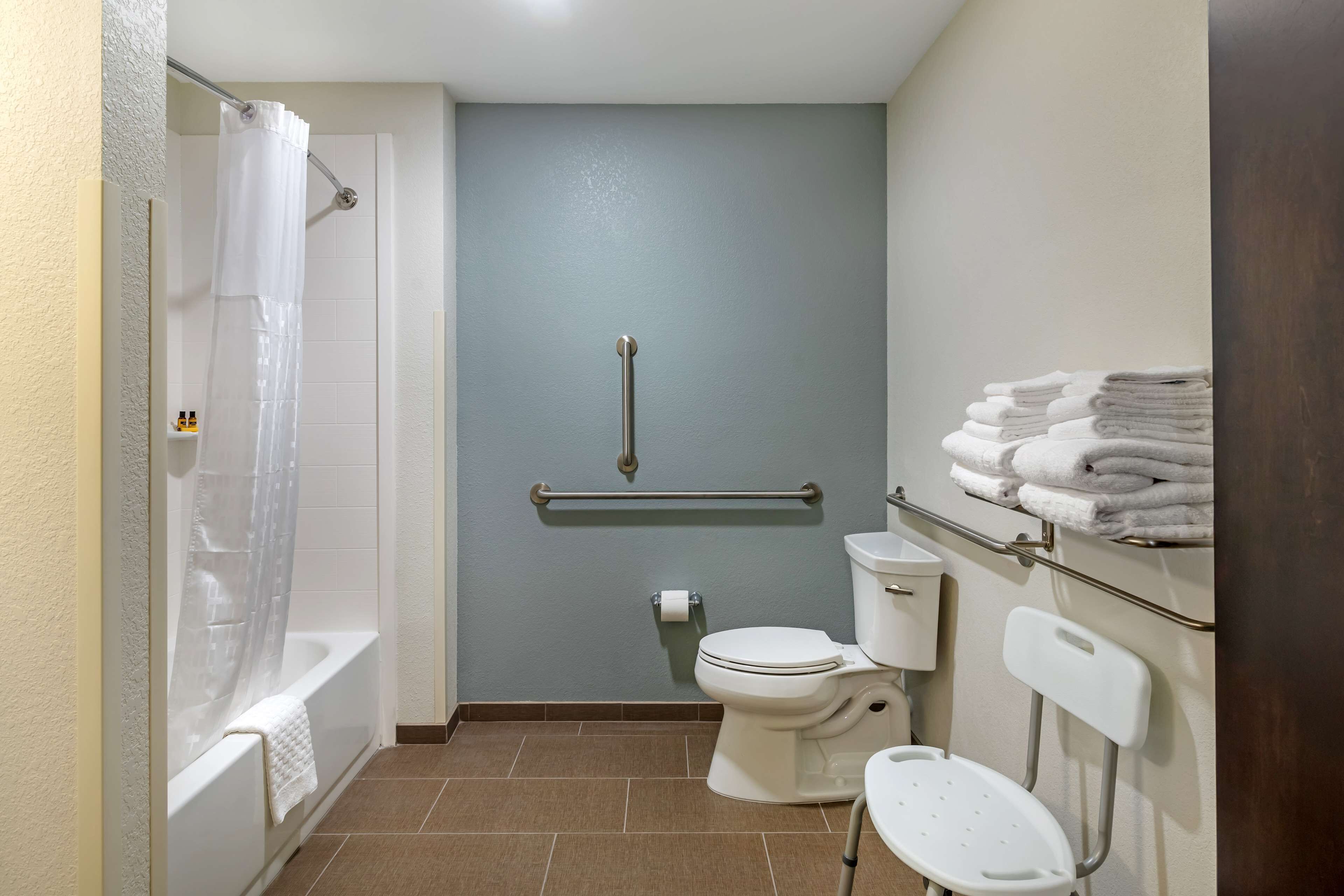 A bathroom with a bathtub, toilet, and a shower curtain.