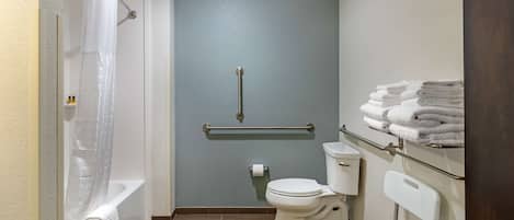 A bathroom with a bathtub, toilet, and a shower curtain.