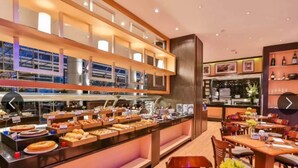 A buffet area with various food items and a seating area with tables and chairs.