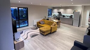 Een modern appartement met een woonkamer, keuken en eethoek.