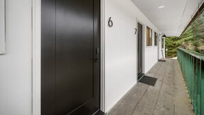 A corridor with doors numbered 6 and 7, leading to rooms. - Comfort, Style & Views | Steps to Tours & Eats (Juneau)