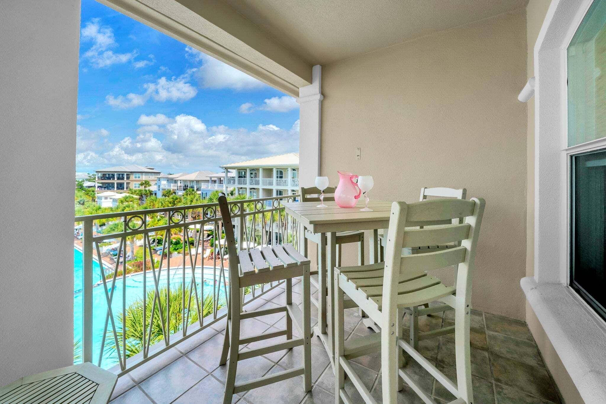 A balcony with a view of a swimming pool and resort buildings.